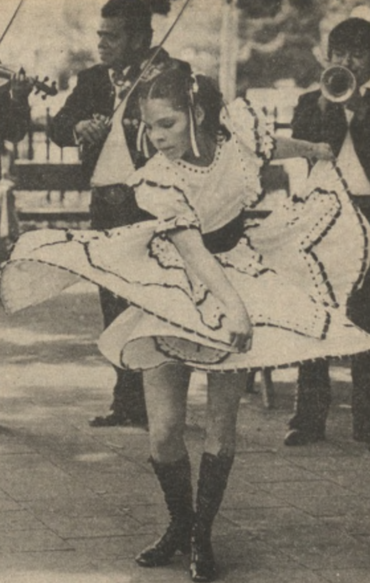 A Chicana woman in a traditional dress is joyfully dancing with a flowing skirt, surrounded by musicians playing instruments.