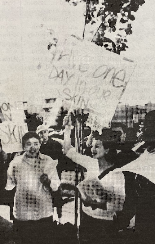 Protesters hold signs reading "Live one day in our skin" during a demonstration. 