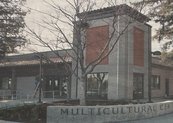 Show thumbnail preview A building with a sign reading Multicultural Center in front. The structure features a tiled roof and large windows.