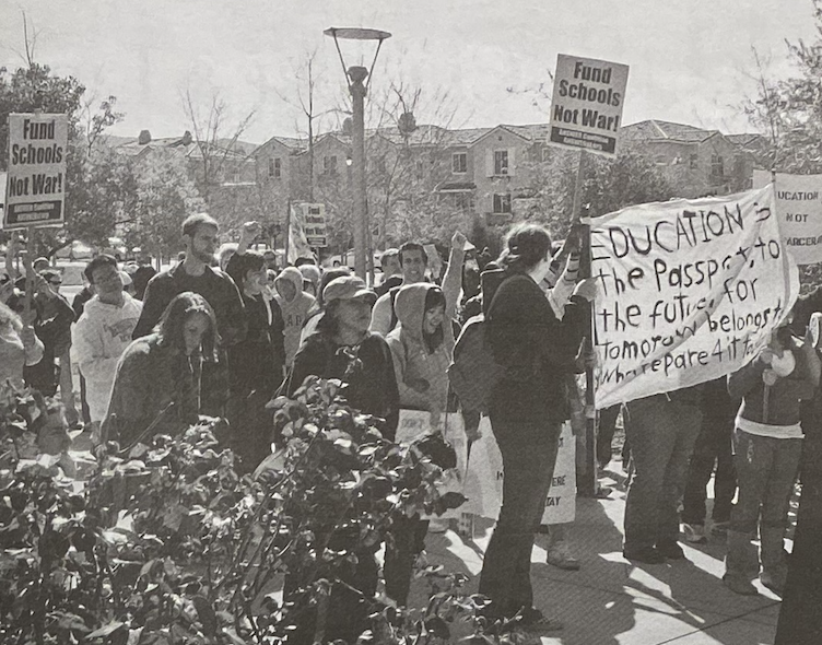 A group of people are marching in a protest. They hold signs reading Fund Schools Not War and Education is the passport to the future. 