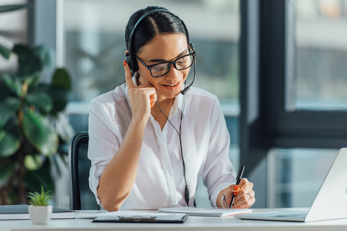 reporter interviewing man woman at desk with headphones
