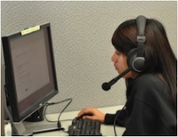Online Tutoring Female Female working on a computer wearing a headset.